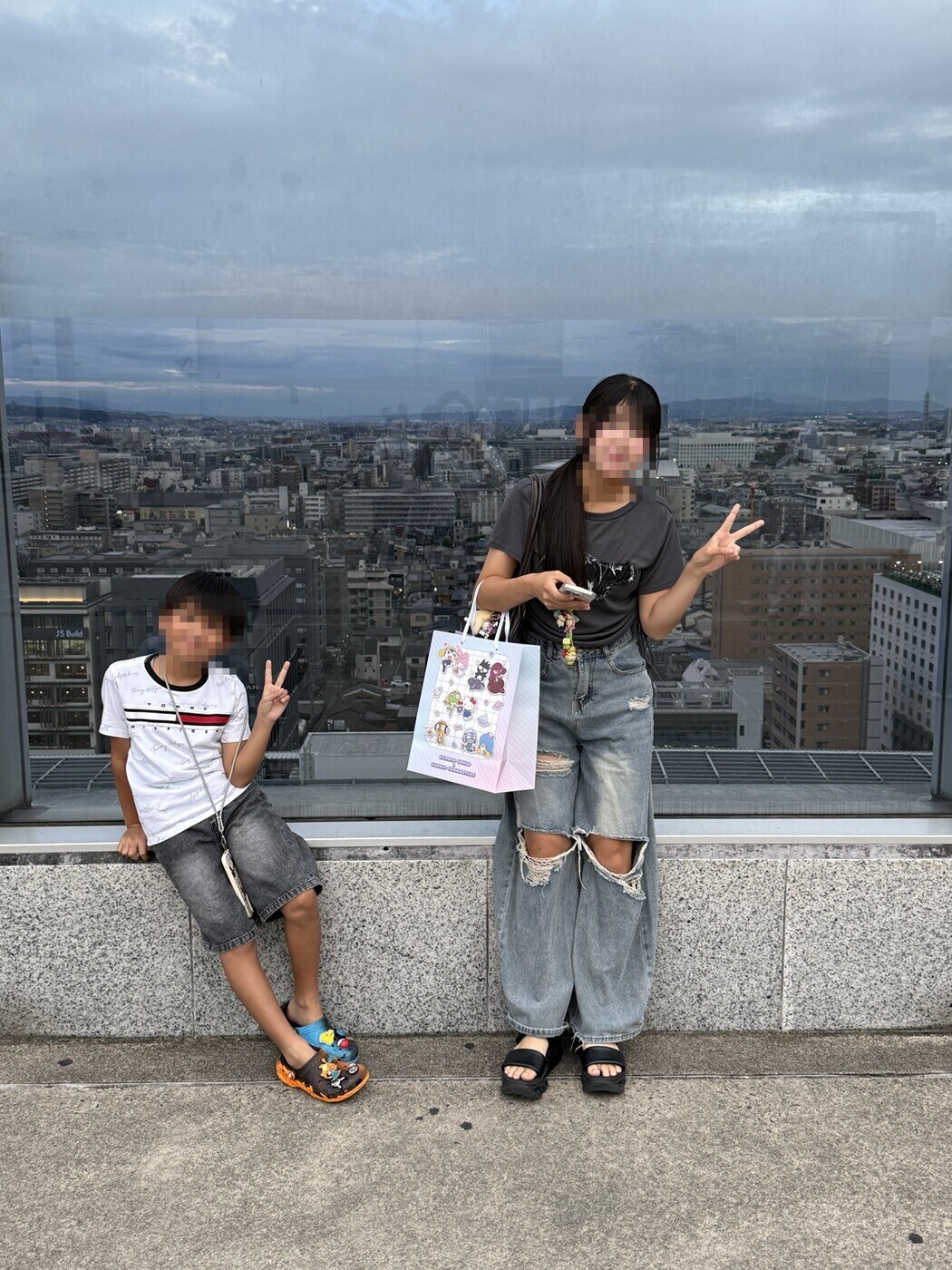 京都の街を背景に、娘と息子。手にはさっそくお買い物袋が😊