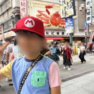 マリオの帽子をかぶった息子と、道頓堀のカニの看板